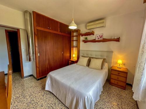 una camera da letto con un letto bianco e una porta di legno di Vinya del mar a Deià