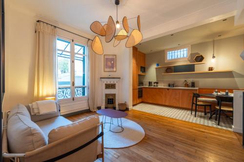 een woonkamer en keuken met een bank en een tafel bij Maison Gabrielle - Welkeys in Charenton-le-Pont