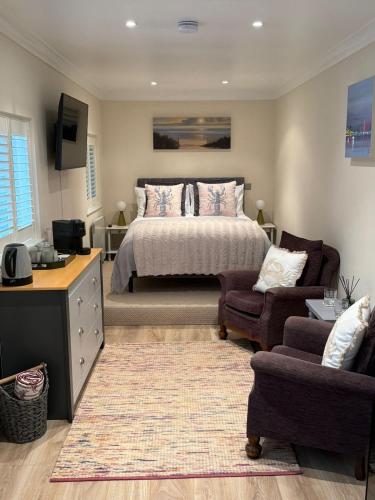 a bedroom with a bed and a couch and a chair at Coastal Escape in Hamworthy