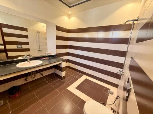 un bagno con lavandino, WC e specchio di Blue Moon Residency Jinnah Super a Islamabad