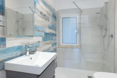 a white bathroom with a sink and a shower at Il Cavo Suites - Elba Affitti in Cavo
