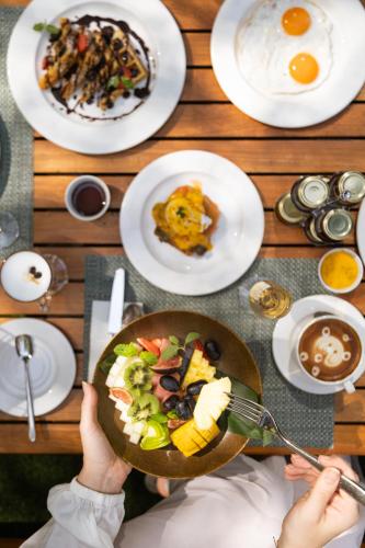 a person holding a plate of food on a table at DoubleTree by Hilton Dubai Jumeirah Beach in Dubai