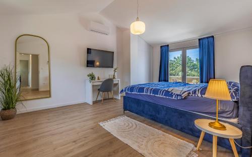 Schlafzimmer mit einem Bett, einem Spiegel und einem Schreibtisch in der Unterkunft Cozy holiday home Ella Nature with pool near the beach in Peroj