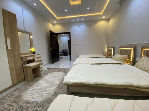 a bedroom with two beds and a mirror at عين دبي للشقق المفروشة-عائلات in Taif