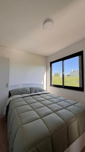 a bedroom with a large bed with a large window at Complejo Nomade Home in Marcos Juárez