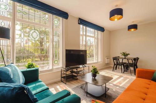 a living room with a couch and a tv at Elysée Suites - Lovely 2 Bed Flat in Southport in Southport