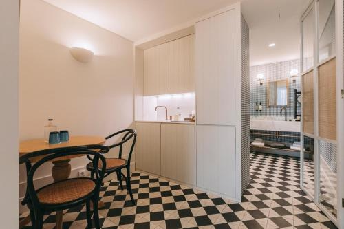 a kitchen with a table and two chairs in a room at Torel Saboaria in Porto