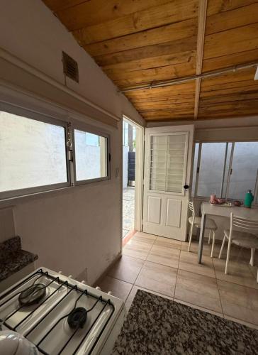 een keuken met een fornuis en een eetkamer met een tafel bij Departamentito Cabral in Tandil