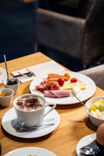 ユショーにあるChâteau De Massillanの食べ物の皿とコーヒーカップが置かれたテーブル