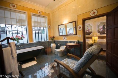 a bathroom with a tub and a toilet and a sink at Hotel Boutique Cultura Manor by Brater in Quito