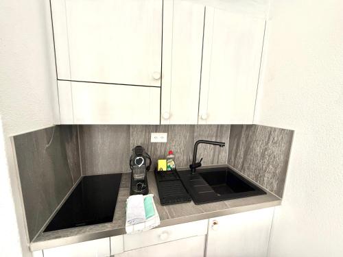 a kitchen counter with a sink and a mixer at Monolocale in centro, Piscina e 400mt da Skilift in St. Moritz