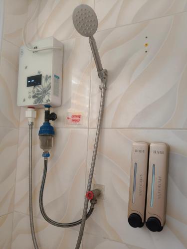 a shower head and a blow dryer on a wall at Speed 8 Inn Moalboal in Moalboal