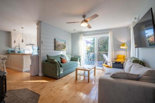 a living room with a couch and a kitchen at Lakeside & Private dock - Le Suisse d-Entrelacs in Entrelacs