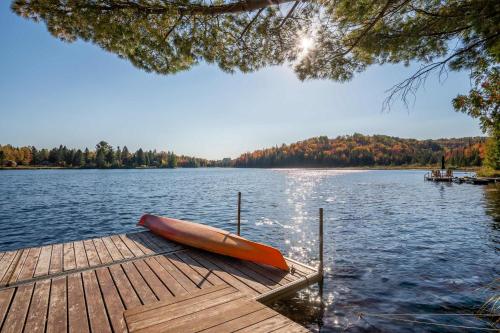 a canoe sitting on a dock on a lake at Lakeside & Private dock - Le Suisse d-Entrelacs in Entrelacs