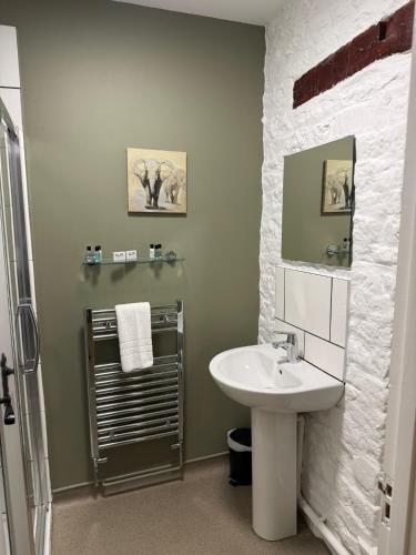 a bathroom with a white sink and a shower at The Bell Inn in Oxford