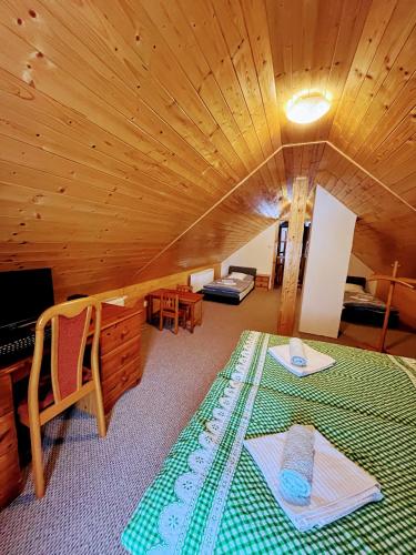 a room with a bed and a wooden ceiling at Chalupa Kocourov in Slavíkov