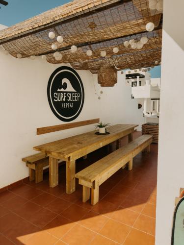 a restaurant with benches and a sign on the wall at Surf&Sleep in Corralejo