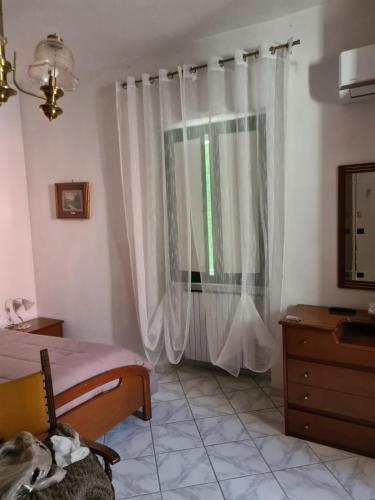 a bedroom with a bed and a window with curtains at Casa Vacanza In Paese in Montecorvino Rovella