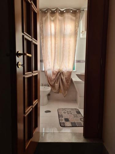 a bathroom with a toilet and a shower curtain at Casa Vacanza In Paese in Montecorvino Rovella