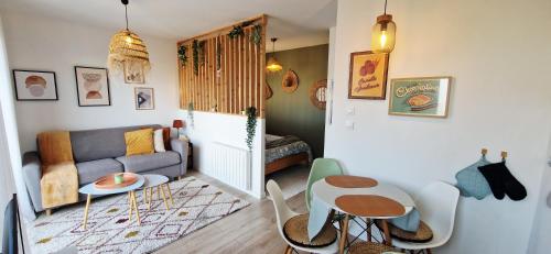 a living room with a couch and a table at Villa Cosy - Proche Bordeaux in Parempuyre