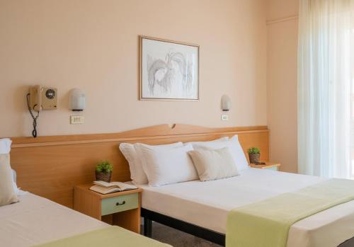 a hotel room with two beds and a window at Milano Simple in Bellaria-Igea Marina