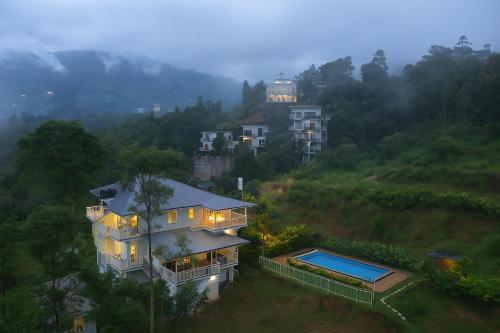 a house on a hill with a swimming pool at Munnar Ice Pellets Resort with Pool by VOYE HOMES in Munnar