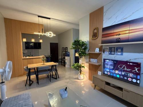 uma sala de estar com televisão e uma sala de jantar em Kamayo Guest House -near Dahican beach em Dahikan