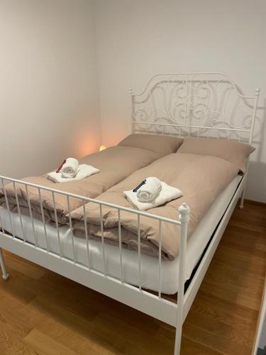 un letto bianco con sopra asciugamani di Spacious light-flooded apartment with garden at Lake Zurich a Männedorf
