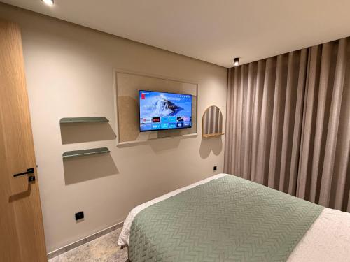 um quarto com uma cama e uma TV na parede em CityZen em Casablanca
