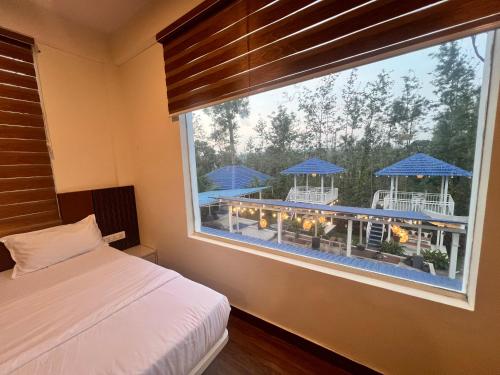 a bedroom with a window with a view of a patio at Aetheria Estate Retreat in Chikmagalūr