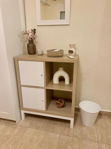 a wooden cabinet with drawers and a mirror at Plagia Oasis Escape in Nea Plagia