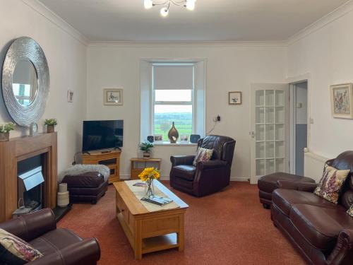 a living room with couches chairs and a television at Muirston Farmhouse - Uk44977 in Ochiltree