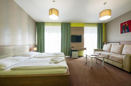 a hotel room with a bed and a couch at Hotel Lučivná in Lučivná