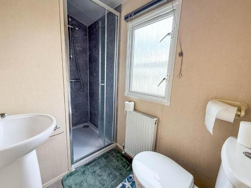 ein Badezimmer mit Dusche, Toilette und Waschbecken in der Unterkunft 6 Berth Caravan With Decking At Naze Marine Holiday Park Ref 17071P in Walton-on-the-Naze