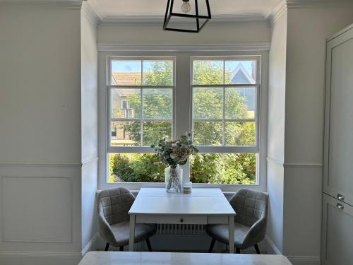 a table and chairs in a room with a window at Seaside apartment in Bexhill