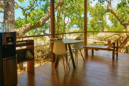 a porch with a table and chairs and a bench at Villa Luzo & Tours in Saonek