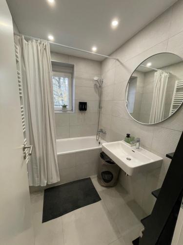 Un baño con lavabo, bañera y espejo. en Apartmán Sihoť - pri Zimnom Štadióne, en Trenčín