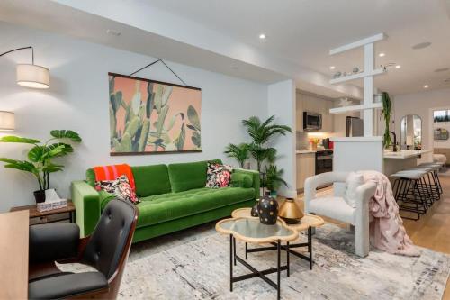 a living room with a green couch and a kitchen at Santuario Kensington - Inner City Escape in Calgary
