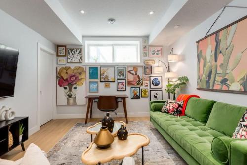 a living room with a green couch and a table at Santuario Kensington - Inner City Escape in Calgary