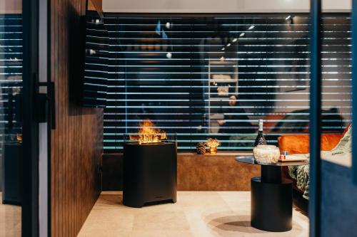 un camino in una stanza con un tavolo e una finestra di Ostravinka - Boutique Cabin a Ostrava