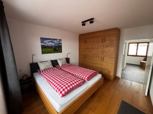 a bedroom with a bed with a red and white blanket at Bergnest 4 in Bivio