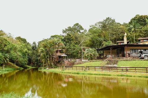 um rio em frente a uma casa com uma casa em Pousada Nosso Bosque em Porto Belo