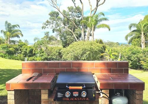 a barbecue grill sitting on a brick bench at Mollymook Ocean View Motel - Welcoming Guests 18 Years and Older in Mollymook