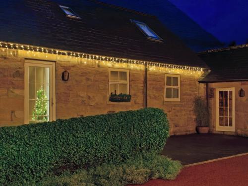 Piglet Cottage في Elsdon: منزل به انوار عيد الميلاد من جهه