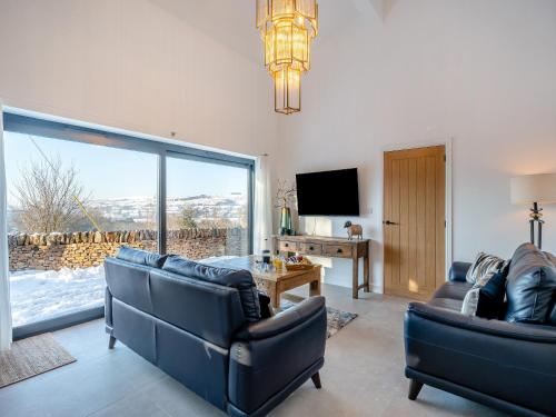 Una sala de estar con dos sofás y una gran ventana. en Moorgate Lodge - Uk47742, en Kelbrook