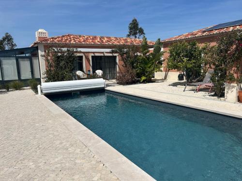 a swimming pool in front of a house at Casita by the Castle in Óbidos