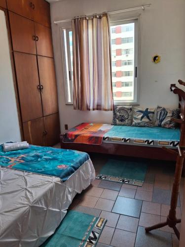 a room with two twin beds and a window at Oasis do Leme in Rio de Janeiro