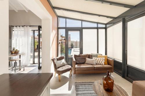a living room with a couch and a chair at Casita by the Castle in Óbidos