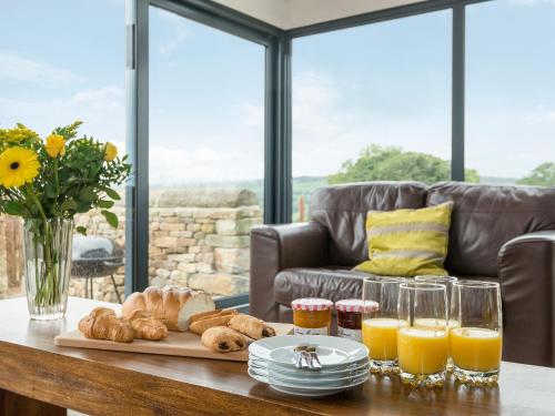 una mesa con una bandeja de pan y zumo de naranja en Moorgate Cottage - Ukc3380, en Kelbrook