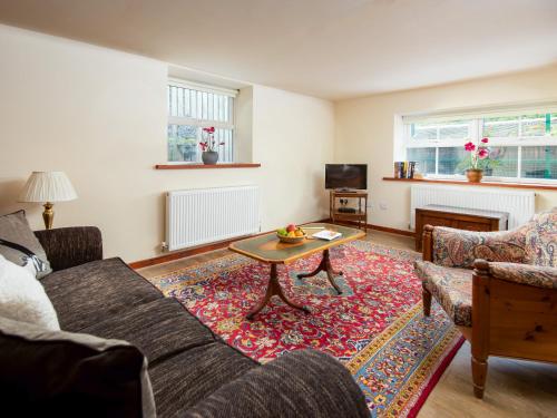 Grooms Cottage في Elsdon: غرفة معيشة مع أريكة وطاولة قهوة
